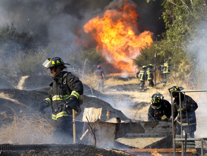 Bomberos combate incendio cercano a viviendas en Renca