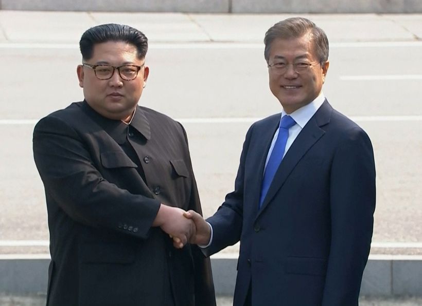 Kim Jong-un y el presidente surcoreano se dan la mano en la línea de la frontera