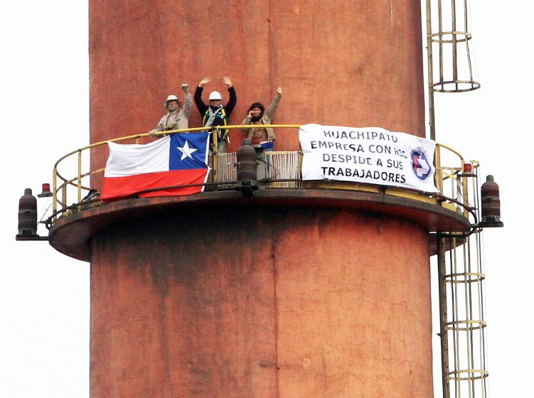 Manifestantes que están en una de las chimeneas de Huachipato no