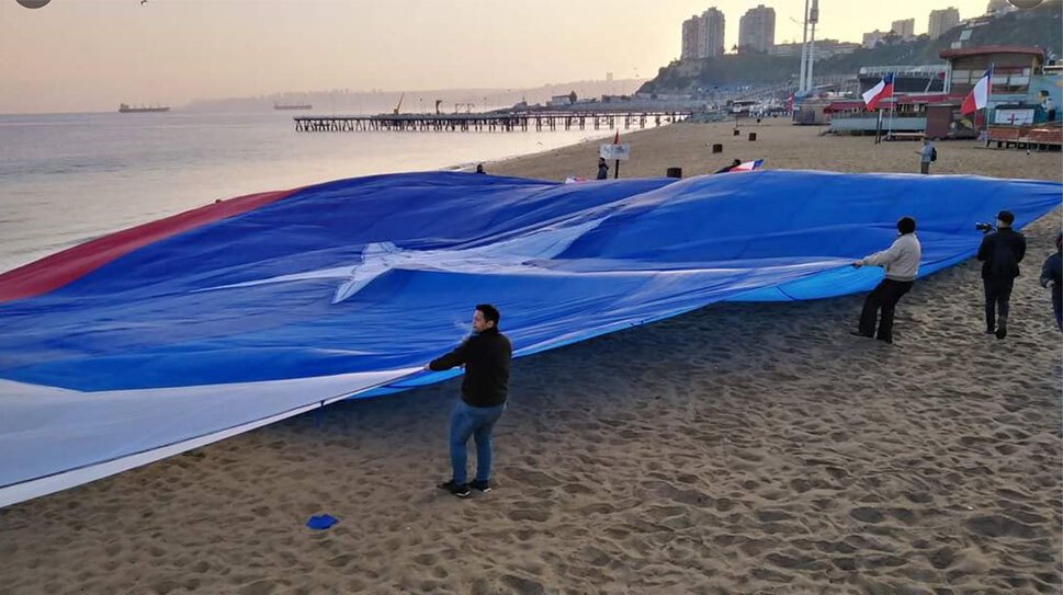 Bandera gigante de Chile se posa sobre Caleta Portales en Valparaíso